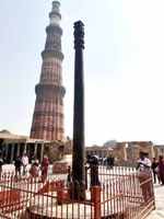 Индийская железная колоннп на фоне кирпичного минарета Кутб-Минар, самого высокого в мире. г. Дели, Индия, февраль 2023г