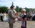 Цветы директору школы Лях В.П. вручает девятиклассница Аня Мурзина